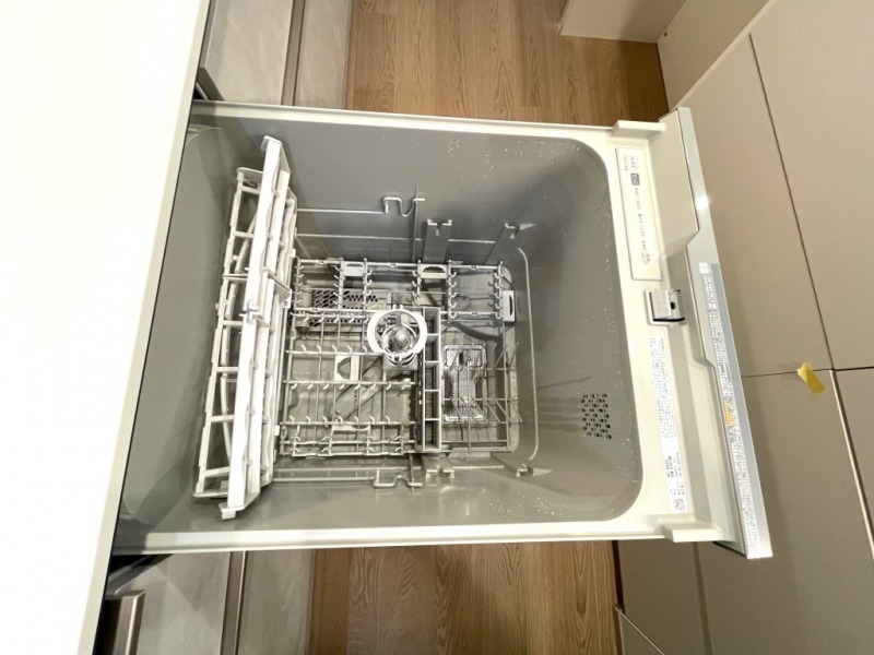 【キッチン：食洗機】最大63L、約6人分、47点の食器収納できるリンナイのビルトイン食器洗浄乾燥機が採用されていて、鍋やフライパンもまとめて洗える食器カゴで可動式レールで形や大きさの違う食器のセットがしやすい構造です。ラクな姿勢で操作ができる上部に操作ボタンを設置した「オールトップコントロール」機能や専用洗剤の除菌性能が活動しやすい温度にコントロールして汚れを落としやすくする「バイタル除菌洗浄」の機能もあります。排気もやさしい温度で、乾燥ファンのみで運転する「からっとキープ」機能で、余熱を利用し隅々まで食器乾燥させ、水槽の臭いなども抑えます。