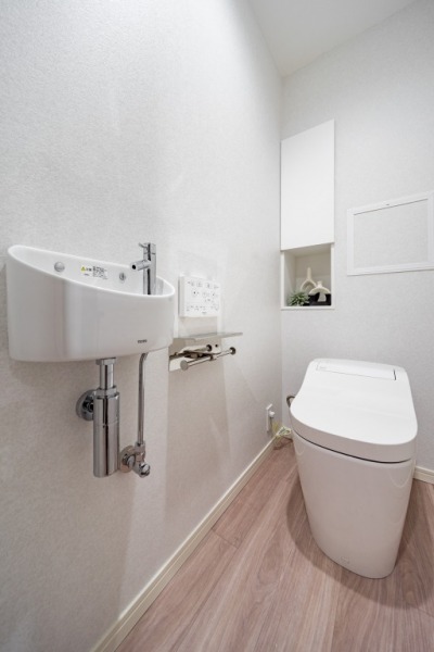 【トイレ】タンクレスのすっきりとしたデザインのウォシュレット付きトイレで、室内は清潔感があり落ち着く上質な空間です。収納棚も設置されており、トイレットペーパーなどの消耗品の収納ができます。便利な専用手洗いスペースも付いています。