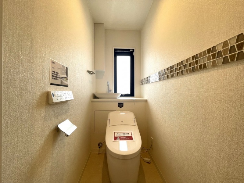【トイレ】タンクレスですっきりとしたデザインのウォシュレット付きトイレです。室内は清潔感があり落ち着ける上質な空間です。便利な専用手洗いスペースがあり、トイレットペーパー等の収納も備えてあります。また窓があるので明るく、こもりがちな臭いも換気ができて快適です。