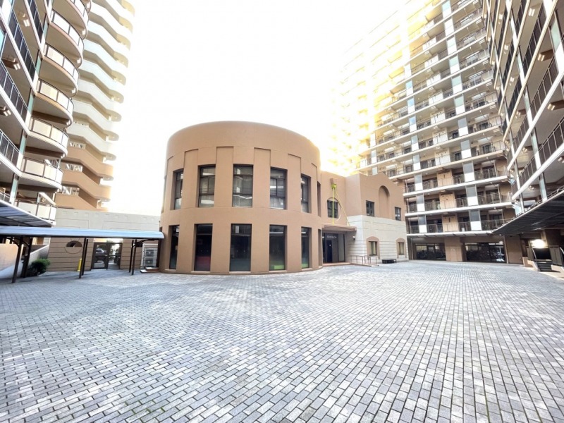 【共用施設外観】敷地の中心には、丸みを帯びた共用施設の建物があります。室内はキッズルーム、キッチンスタジオ、コミュニティサロン、リーディングルーム、集会室、バンケットフォーラムなどがあり、共用施設も充実しています。
