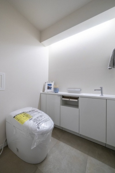 【トイレ】タンクレスのすっきりとしたデザインのウォシュレット付きトイレで、室内は清潔感があり落ち着く上質な空間です。吊戸棚も設置されており、トイレットペーパーなどの消耗品の収納ができます。便利な専用手洗いスペースも付いています。