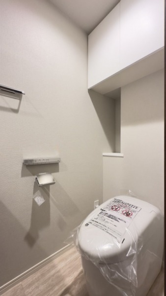 【トイレ】タンクレスのすっきりとしたデザインのウォシュレット付きトイレで、室内は清潔感があり落ち着く上質な空間です。