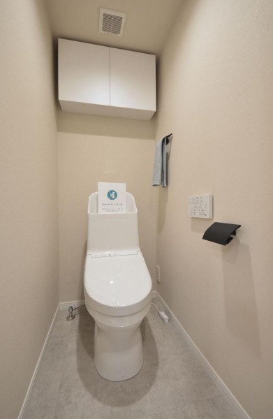 【トイレ】すっきりとしたデザインで清潔感があり、落ち着ける空間です。トイレもうれしいウォシュレット機能付きです。吊戸棚も設置されており、トイレットペーパーなどが収納できます。