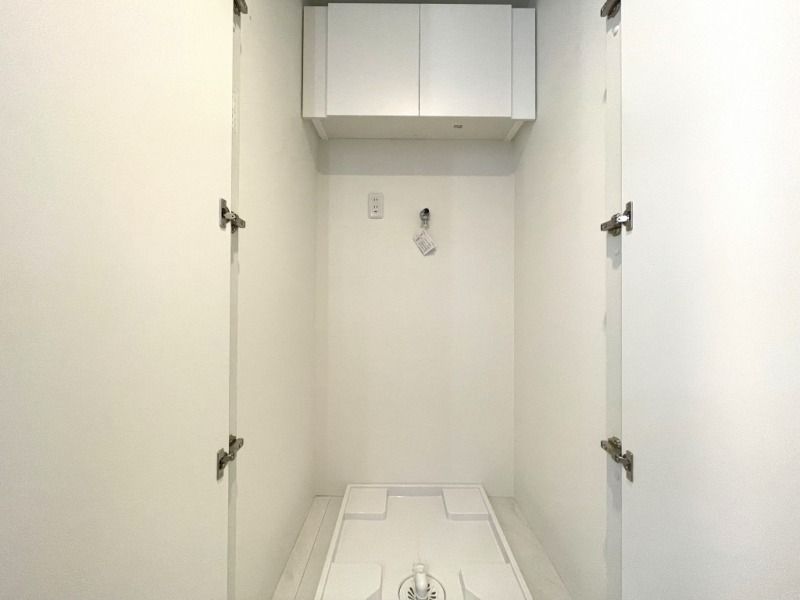 【洗面室:洗濯置場】洗濯機置き場には、防水パンと洗濯機専用水栓・コンセント差し込み口が設置され、上部には可動式の収納棚も備えてあり、洗剤やシャンプーストックなども収納できます。扉も付いていて生活感も出にくく、洗面室もすっきりご利用頂けます。