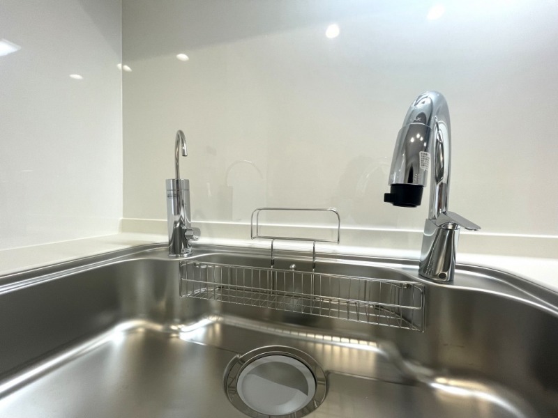 【キッチン:水栓】INAX製タッチレス水栓ナビッシュが設置されていています。人気のスワンネック水栓で、手やモノを感知して吐水と止水が自動センサーで触れずに行え、衛生的です。ワンアクションで吐水や混水、シャワーの切り替えも可能で機能性と使いやすさに優れています。デザインだけでなく大きな洗い物もしやすく、蛇口部分がホースのように伸ばせるのでシンクも洗いやすい構造です。また省エネで節水もできます。LIXIL製のワークトップ上でカートリッジの簡単交換ができる、浄水器内蔵型専用水栓が付いていて、浄水器一体型の水栓のように、浄水と混ざって吐水されることもなく、メインの水栓を利用中にも別途使用できて便利です。