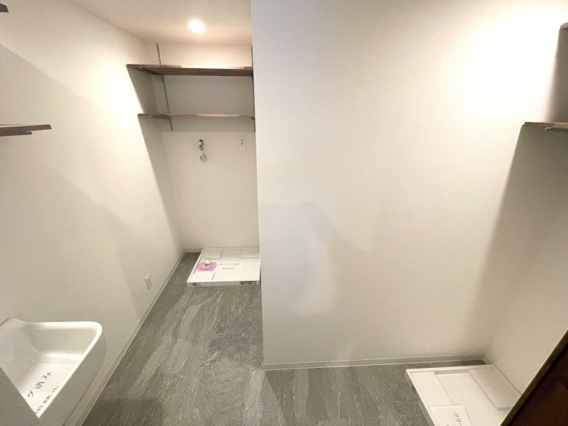 【ユーティリティ】防水パンと洗濯機専用水栓が2つずつ設置され、洗濯機と乾燥機をそれぞれ置くこともでき、お掃除の際の雑巾洗いや汚れものの予洗いなどにも便利なスロップシンクもあり、機能的なユーティリティルームとなっています。吊り棚も備えてあるので、タオルや洗剤やストック置き場としても重宝します。