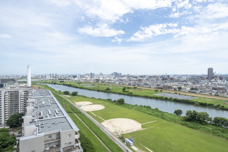 【バルコニーからの眺望】眼下は一面の多摩川ビューです。河川敷沿いのグリーンも広がり、開けた爽快な眺望です。向こう岸には川崎方面の街並みが一望できます。