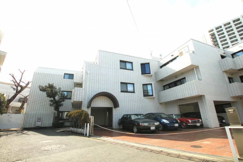 【外観】閑静な住宅街に位置する、ホワイトのタイル張りにブラックサッシがアクセントとなった重厚感のある雁行型の外観です。1982年12月築、地下1階地上3階建、総戸数31戸の低層レジデンスです。