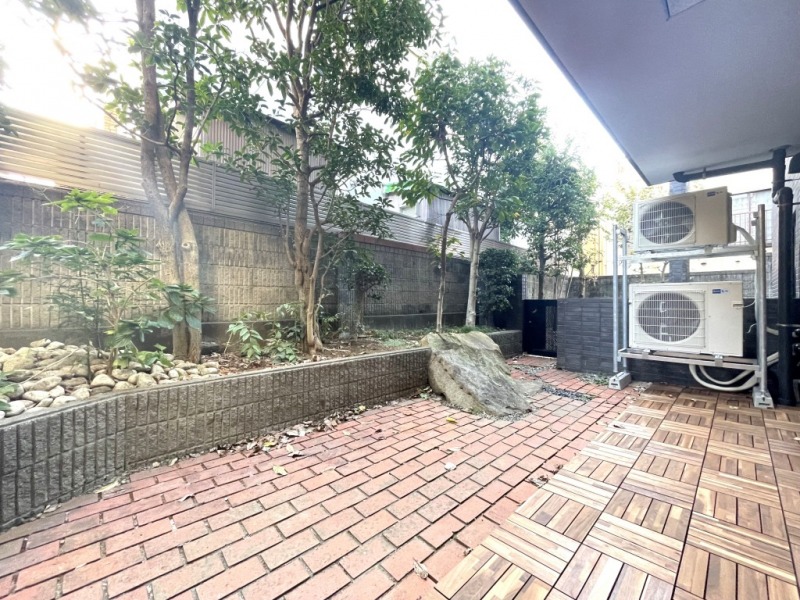 【リビング側テラス】南西向きの陽光が注ぐ気持ちの良いテラスです。レンガ調タイル仕様で、テラス部分にはウッドパネルが敷かれています。植栽に囲まれていて、視線も気にならず、グリーンでリラックスもできます。テーブルやチェアを置いてカフェタイムなど、リフレッシュや寛ぎのスペースとしてもゆったりお過ごし頂けるテラスです。