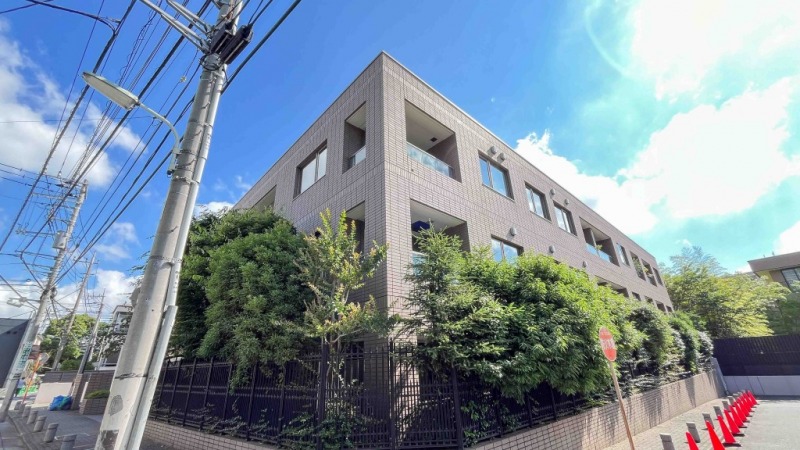 【外観】御殿山の高台にある閑静な住宅街に位置し、ベージュタイル張りの重厚でモダンな印象の外観です。2003年1月築、大林組施工、大京旧分譲の地下1階地上3階建、総戸数15戸の低層ハイグレードレジデンスです。