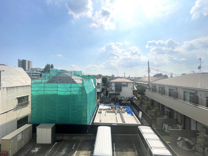 【ルーフバルコニーからの眺望】眼下は、駐車場で、低層の建物が多く抜けもあり、広い空も仰げる気持ちの良い眺望です。