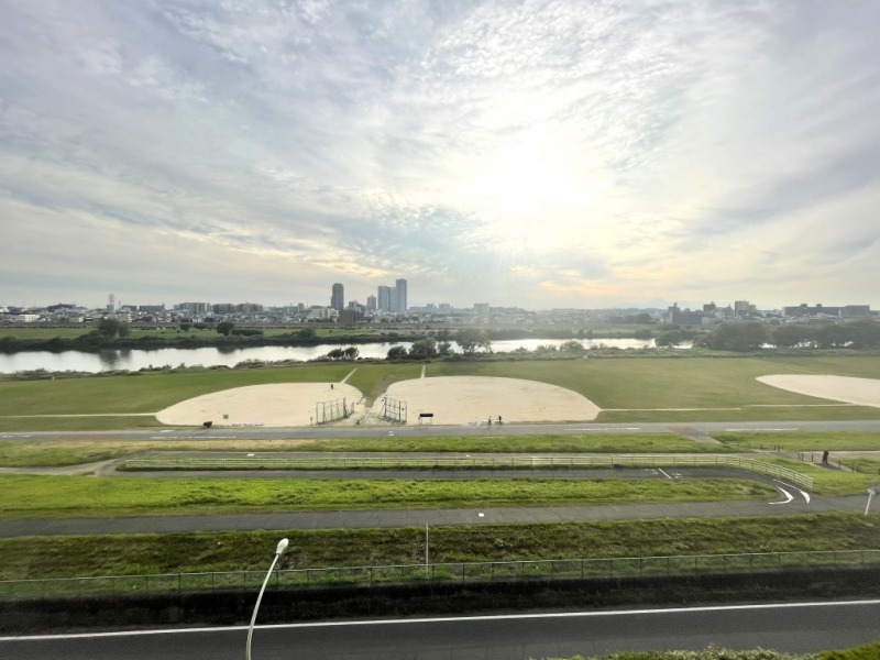 【住戸からの眺望】前面は、視線を遮るようなものはなにも無く、緑地と多摩川が一面に広がる開けたパノラマビューです。川崎方面のタワーマンションも望めます。開放感のある広い空が仰げ、空色の移ろいも感じられる爽快な眺望です。