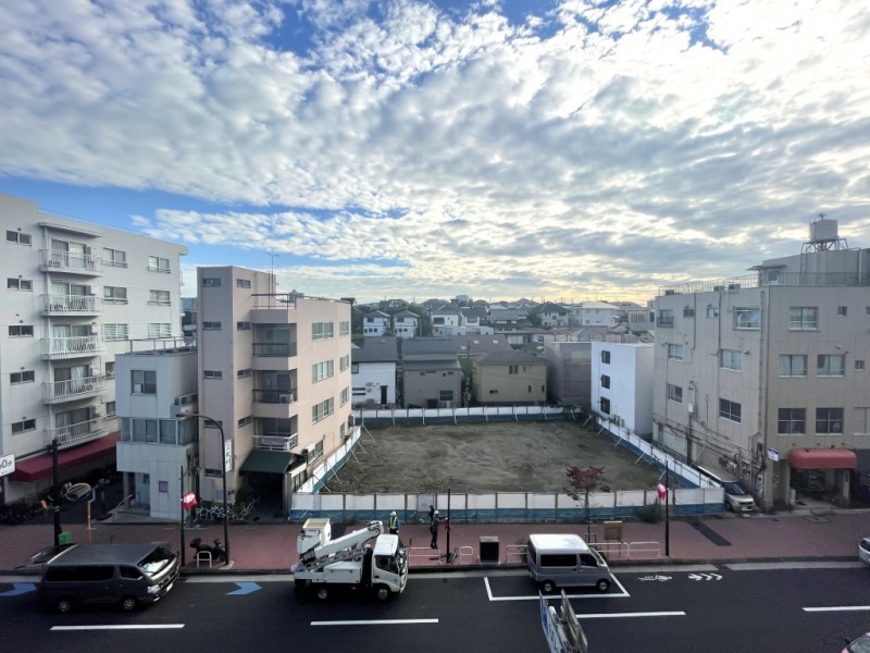 【住戸からの眺望】前面は現在更地(元ガソリンスタンド)で、遠くの家々まで抜けています。周辺も高層の建物は少なく、開けていて広い空も仰げる爽快な眺望です。
