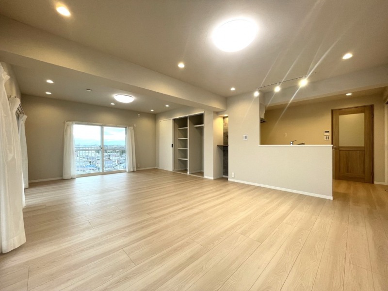 【LDK:約25.0帖】ライトベージュを基調とした内装に、木目の美しいフローリングや建具で、木のぬくもりを感じるナチュラルモダンな雰囲気のリビングダイニングとなっています。キッチン横には、リビング収納があり、可動納とハンガーパイプと枕棚が設置されていて、日常よく利用する日用品などを収納したり、良く着るアウターを掛けたりと、すぐし入れできる場所にあるので、来客時のクロークとしても利用できます。