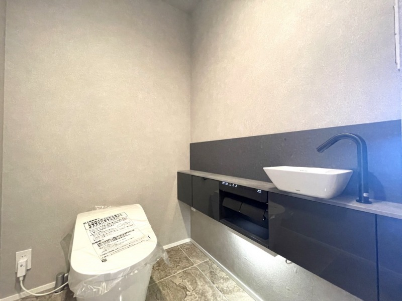 【トイレ】タンクレスのすっきりとしたデザインの汚れもつきにくい洗浄付きトイレで、室内は清潔感がありシックで落ち着く上質な空間です。便利な専用手洗いスペースも設けられています。