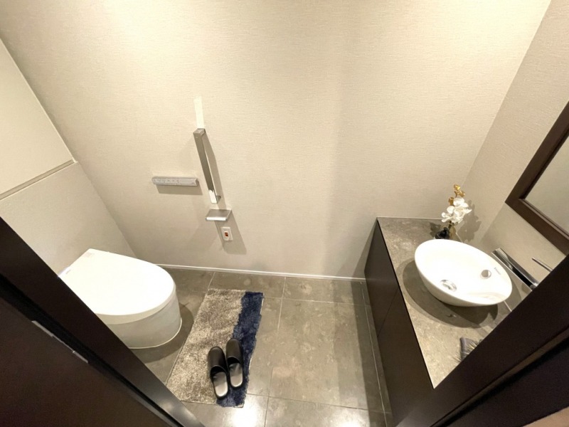 【トイレ】タンクレスのすっきりとしたデザインの汚れもつきにくい洗浄付きトイレで、室内は清潔感がありシックで落ち着く上質な空間です。ミラー付きの便利な専用手洗いスペースも設けられています。