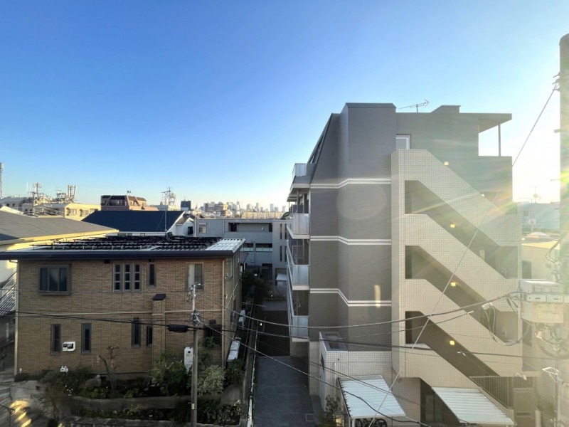 【住戸からの眺望】眼下は道路なので、前面の建物までは距離が保たれ、低層の建物も多く、奥の景色も抜けています。広い空も仰げる眺望です。
