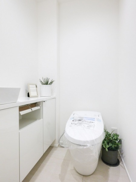 【トイレ】タンクレスのすっきりとしたデザインの汚れもつきにくい洗浄付きトイレで、室内は清潔感があり落ち着く上質な空間です。便利な専用手洗いスペースも設けられています。