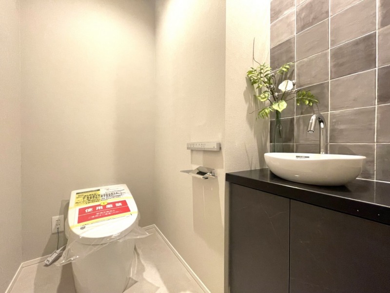【トイレ】タンクレスのお手入れもしやすいすっきりとしたデザインの洗浄付きトイレで、室内は清潔感があり、落ち着く上質な空間です。タイル貼りのおしゃれな専用手洗いスペースも設けられています。