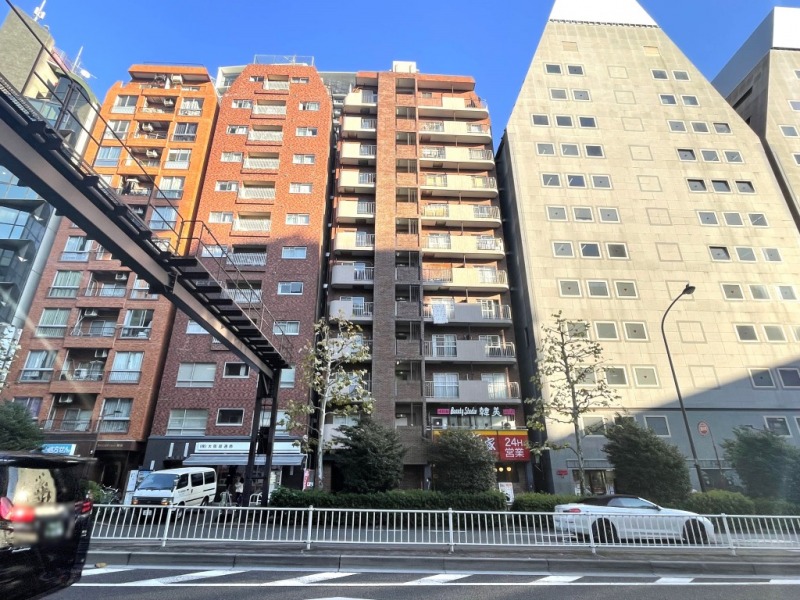 【外観】レンガ調のタイル張りにベージュのバルコニーがコントラストになった外観です。1980年10月築、太陽建設施工の地上12階建、総戸数57戸のアーバンレジデンスです。1階には牛丼チェーン店、隣接する建物には郵便局、反対側に隣接する建物には雑貨店、薬局、歯科院、ガソリンスタンドが並んでいます。