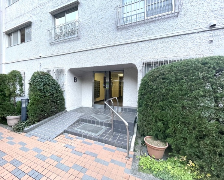 【エントランス】前面道路より奥まった所に位置する、プライバシー性の高いエントランスです。スロープが設けられており、ベビーカーや車いすの通行も安心です。