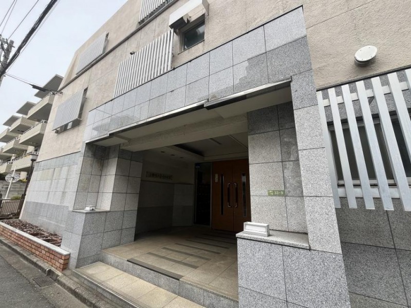 【エントランス】通りより少し奥まった位置にある、重厚感のあるストーン貼りのエントランスです。