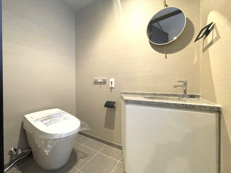 【トイレ】タンクレスの温水洗浄機能付きトイレで、お手入れもしやすくすっきりしていて、室内は清潔感があり落ち着く上質な空間です。ミラー付きの便利な専用手洗いスペースも設けられています。