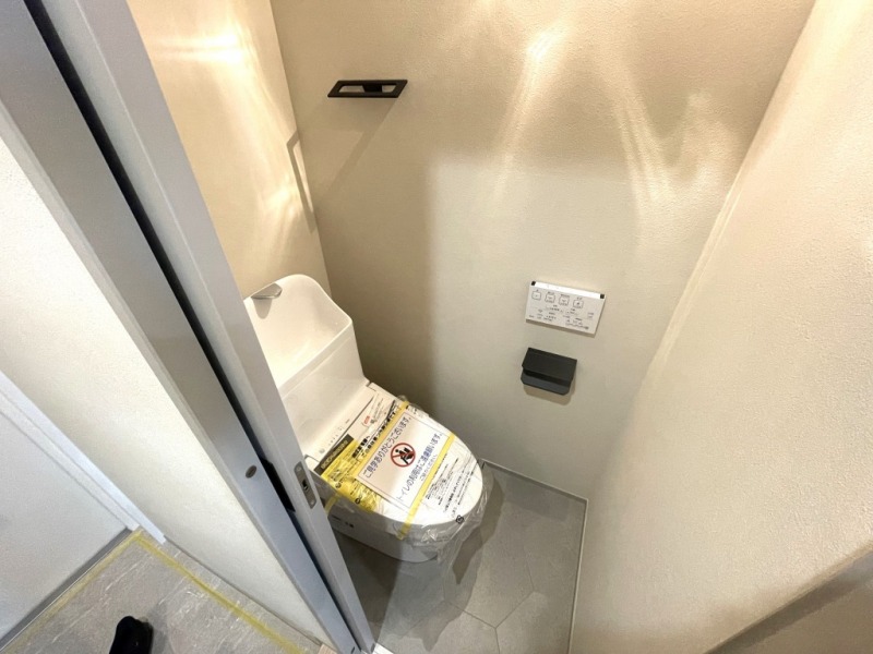 【トイレ】室内はホワイトを基調としていて清潔感があり、すっきりとした落ち着ける空間です。トイレもうれしい温水洗浄機能付きです。吊戸棚も設置されており、トイレットペーパーなどが収納できます。