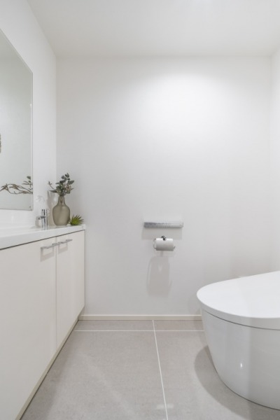 【トイレ】タンクレスのすっきりとしたデザインで、お手入れもしやすい温水洗浄機能付きトイレです。室内は清潔感があり落ち着く上質な空間です。ミラーと収納付きの便利な専用手洗いスペースも設けられています。