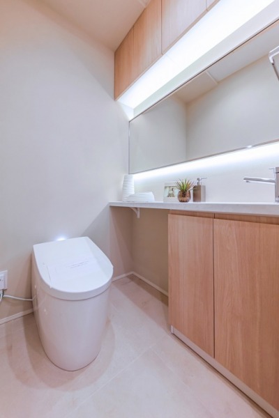 【トイレ】お手入れもしやすいタンクレスで、すっきりとしたデザインの温水洗浄機能付きトイレです。室内は清潔感があり落ち着く上質な空間です。収納・カウンター・ワイドミラーの付いた便利な専用手洗いスペースも設けられています。