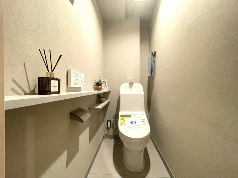 【トイレ】すっきりとしたデザインで清潔感があり、落ち着ける空間です。トイレもうれしい洗浄機能付きです。カウンターが設けられ、ちょっとした物が置ける仕様です。