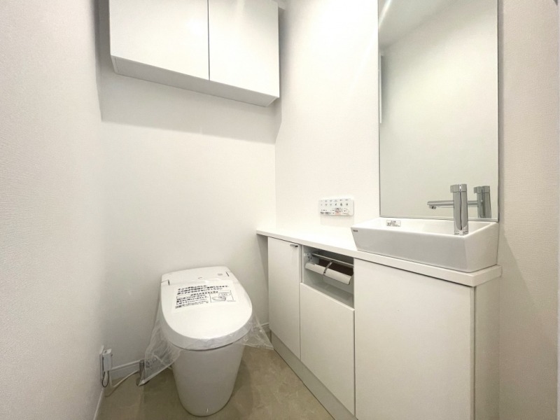 【トイレ】お手入れもしやすいタンクレスで、すっきりとしたデザインの温水洗浄機能付きトイレです。室内は清潔感があり落ち着く上質な空間です。カウンター付きの便利な専用手洗いスペースも設けられています。