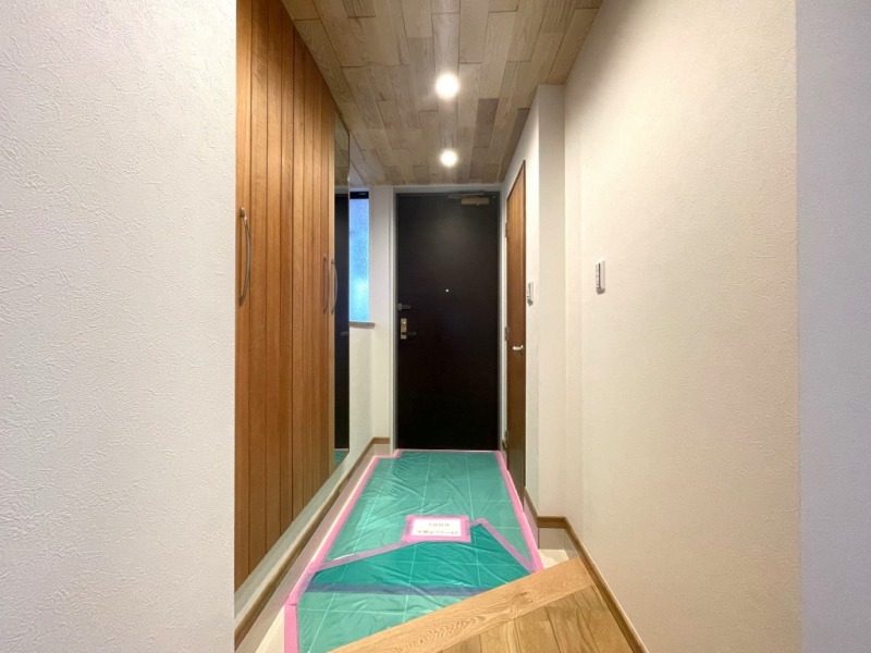【玄関】玄関は天井やフローリングなども天然無垢材を使用し、フロアはホワイトタイル敷の上品な空間となっています。高さのあるシューズクローゼットが設置されており、たっぷりのシューズが収納できます。フロートタイプなのでお掃除もしやすく、玄関をさらに一回り広く感じさせます。姿見も付いていて、お出掛け前の身だしなみチェックもできます。