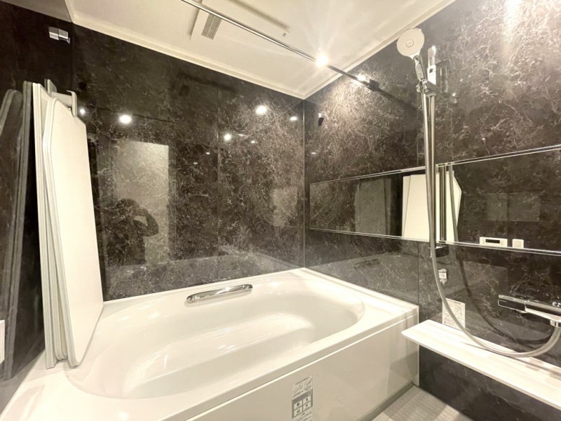 【浴室】ラグジュアリーな落ち着いた内装で、1620サイズのゆったりとしたリラックス空間となっています。大判のシャワーヘッドや空間を広く感じさせるワイドミラーも備えています。保温性の高い専用の風呂ふたも備えています。浴室換気乾燥機付きで、バスタイムも快適です。室外干しができない梅雨や花粉の時期のお洗濯にも活躍します。