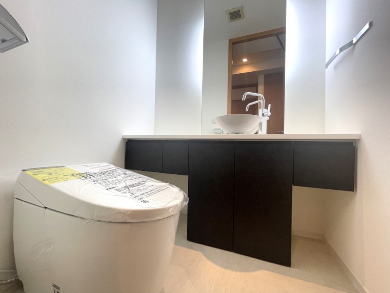 【トイレ】お手入れのしやすいタンクレスで、すっきりとしたデザインの温水洗浄機能付きトイレです。室内は清潔感があり落ち着く上質な空間です。便利な専用手洗いスペースも設けられています。