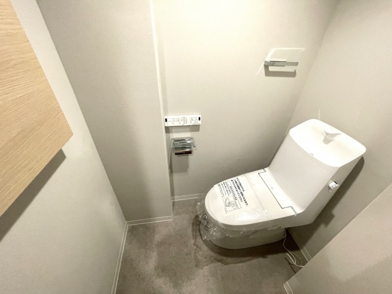 【トイレ】すっきりとしたデザインで清潔感があり、落ち着ける空間です。トイレもうれしい洗浄機能付きです。小物収納も設置されています。