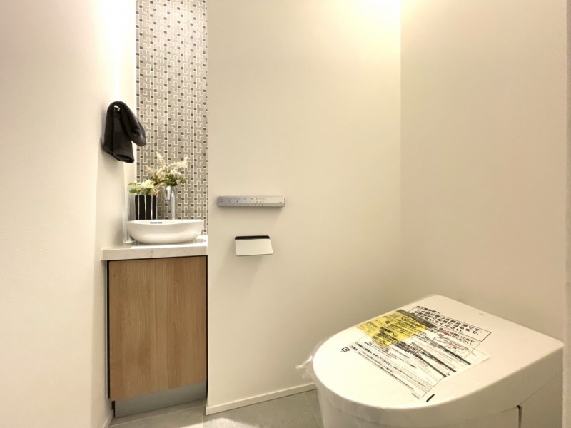 【トイレ】お手入れのしやすいタンクレスで、すっきりとしたデザインの温水洗浄機能付きトイレです。室内は清潔感があり落ち着く上質な空間です。便利な専用手洗いスペースも設けられています。