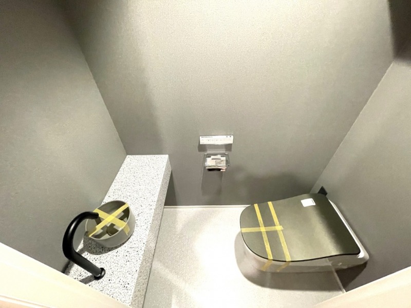 【トイレ】お手入れのしやすいタンクレスで、すっきりとしたデザインの温水洗浄機能付きトイレです。室内は清潔感があり落ち着く上質な空間です。トイレットペーパーなどが収納できる吊戸棚も設置されています。カウンター付きの便利な専用手洗いスペースも設けられています。