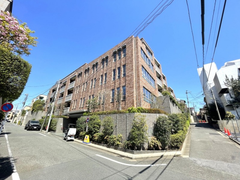 【外観】閑静な住宅街に佇むブラウン系のモザイクタイル張りで、スリットウィンドウが美しく並ぶ気品高い外観です。2004年9月築、北野建設施工、近鉄不動産・東急不動産旧分譲の地上5階建、総戸数38戸のハイクラス低層レジデンスです。井の頭線「池ノ上」駅徒歩8分、小田急線「下北沢」駅も利用可能。都心主要エリアへの軽快なアクセスに加え、環七通りや淡島通りも近く、車移動にも便利です。緑に包まれた落ち着きと都心近接の利便性を両立しています。