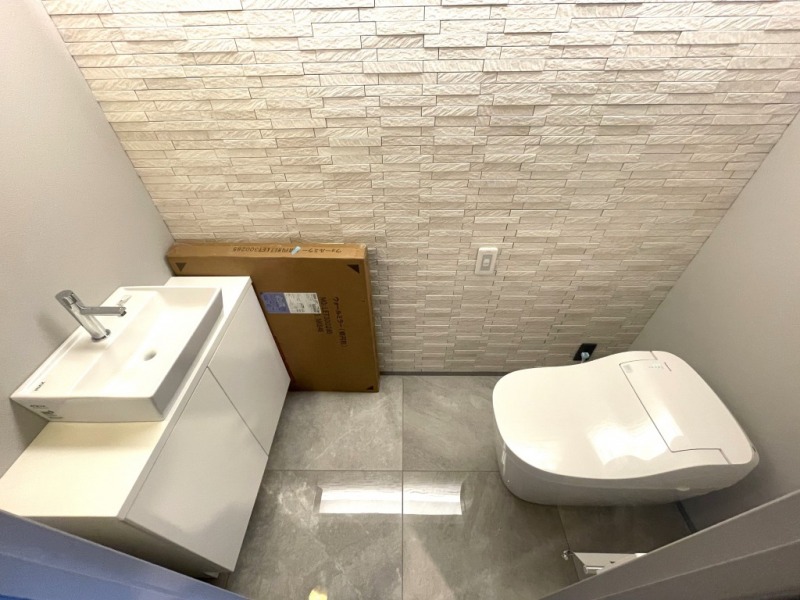 【トイレ】お手入れのしやすいタンクレスで、すっきりとしたデザインの温水洗浄機能付きトイレです。室内は清潔感があり落ち着く上質な空間です。カウンター付きの便利な専用手洗いスペースも設けられています。