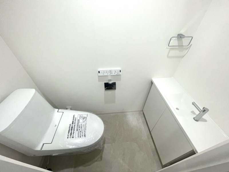 【トイレ】すっきりとしたデザインで清潔感があり、落ち着ける空間です。トイレもうれしい洗浄機能付きです。カウンター付きの便利な専用手洗いスペースも設けられています。