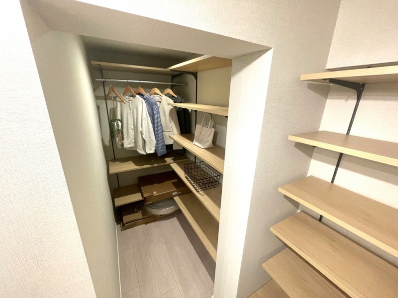 【DEN:約2.7帖(WIC)】奥にはシェルフがずらっと並び、洋服はもちろんのこと、日々使用するお掃除用品や、防災グッズ、日用雑貨のストックなどを収納するのにも重宝します。お持ちの本が多い方は書庫としても利用でき、来客時にはクロークとしても利用できて便利です。