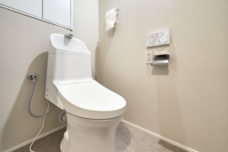 【トイレ】すっきりとしたデザインで清潔感があり、落ち着ける空間です。トイレもうれしい洗浄機能付きです。戸棚も設置されており、トイレットペーパーなどが収納できます。