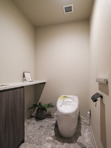 【トイレ】お手入れのしやすいタンクレスで、すっきりとしたデザインの温水洗浄機能付きトイレです。室内は清潔感があり落ち着く上質な空間です。カウンター付きの便利な専用手洗いスペースも設けられています。