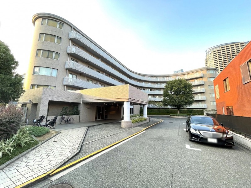 【外観】港区三田1丁目の高台に位置した約3,800㎡もの広大な敷地に、大きなアールを描いたエレガンスなフォルムのホテルのような佇まいです。1991年10月築、竹中工務店・五洋建設施工、地下1階付地上7階建、総戸数49戸のハイクラスレジデンスです。南北線「麻布十番」駅徒歩5分と駅近の好立地。六本木や麻布エリアへのアクセスが良好で、都心を自在に使いこなせます。首都高速も至近で車利用も快適です。「麻布十番商店街」やスーパーが徒歩圏内にあり、日常の買い物に便利。「芝公園」や「有栖川宮記念公園」も徒歩圏で、自然を感じる散策も楽しめます。大使館やインターナショナルスクールも点在し、国際色豊かな住環境です。