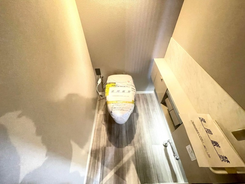 【トイレ】お手入れのしやすいタンクレスで、すっきりとしたデザインの温水洗浄機能付きトイレ。室内は清潔感があり落ち着く上質な空間です。カウンター付きの便利な専用手洗いスペースも設けられています。