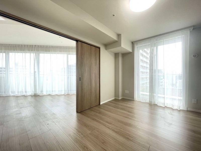 【洋室:6.06帖】南向きの採光があり、陽当たりが良く過ごしやすい洋室です。隣接するリビングの引き戸を閉じればプライベートスペースに、全開にするとリビングと一体化でき、開放感や採光、風通りが倍増し、広々とフレキシブルに活用できます。