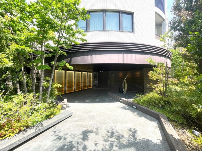 【エントランス】植栽に彩られたアプローチが住まう方を優しく迎える、落ち着きと品格を感じさせる重厚感のあるエントランスです。