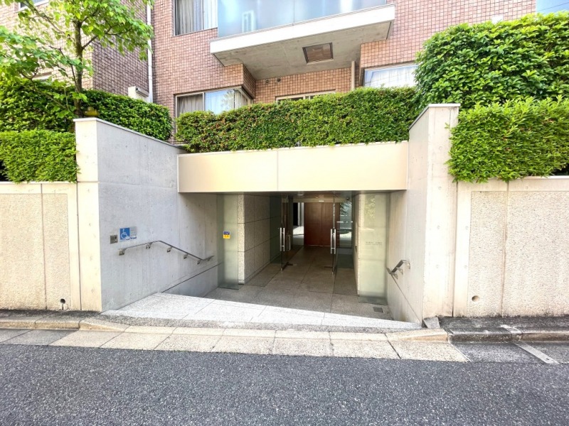 【エントランス】優しいグリーンで彩られ、前面道路より奥まった所に位置する、プライバシー性の高いエントランスです。上質感あるエントランスアプローチが、住まう方やゲストを優雅に迎え入れます。
