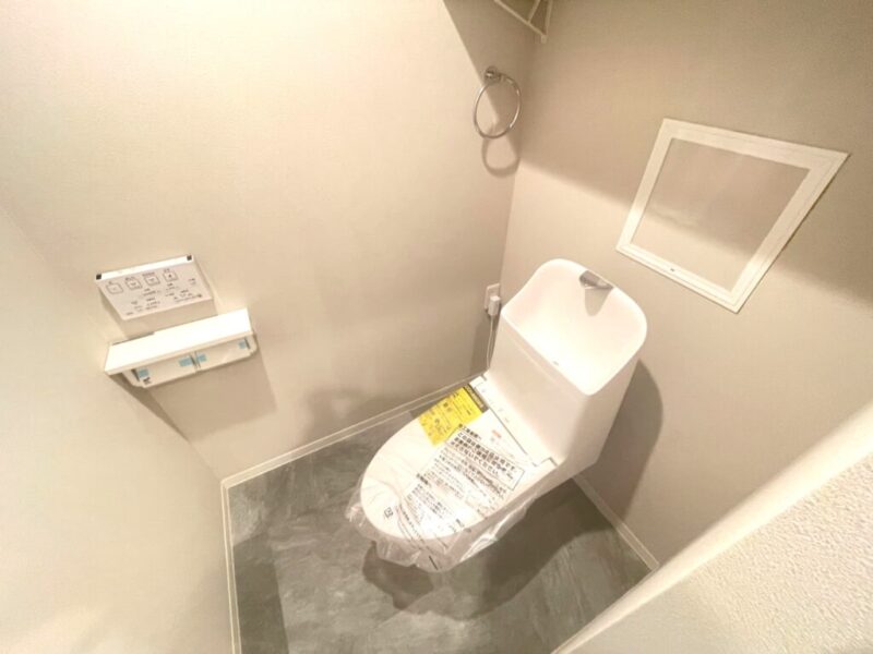 【トイレ】すっきりとしたデザインで清潔感があり、落ち着ける空間。トイレは温水洗浄機能付きです。吊戸棚も設置されており、トイレットペーパーなどが収納できます。